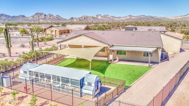 exterior space with a tiled roof, fence private yard, a mountain view, and stucco siding