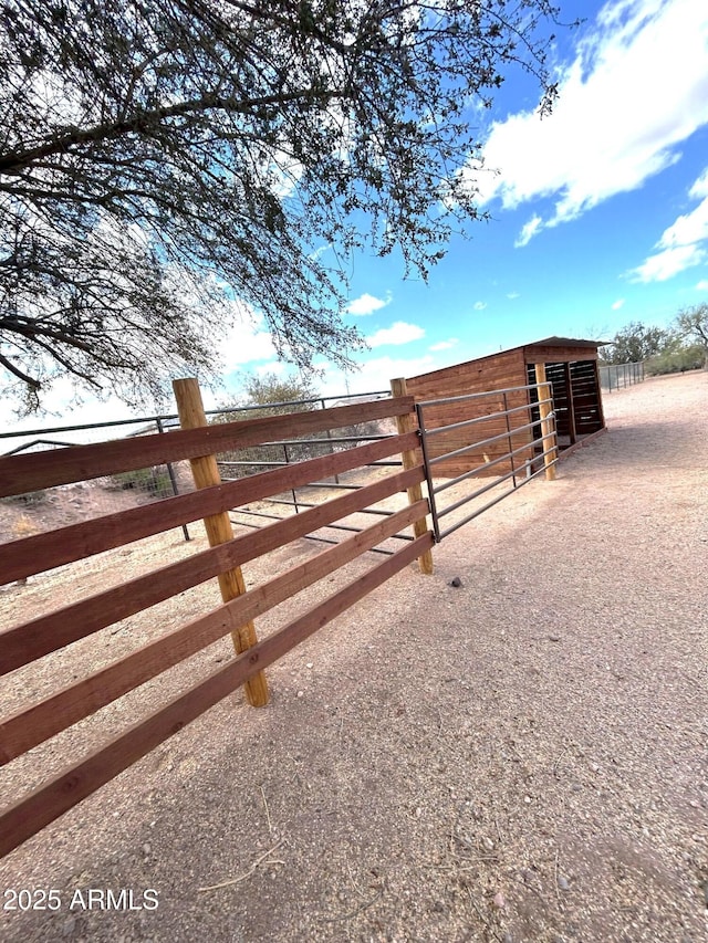 view of gate featuring an outbuilding and an exterior structure