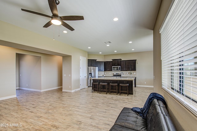 living area with light wood-type flooring, baseboards, visible vents, and recessed lighting