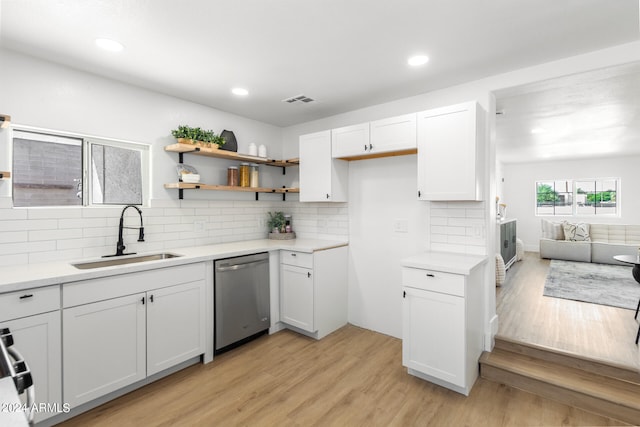 kitchen featuring decorative backsplash, light hardwood / wood-style flooring, stainless steel appliances, sink, and white cabinetry