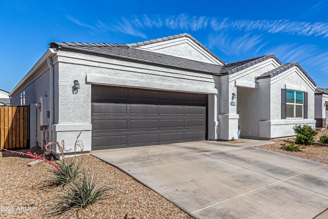 single story home featuring driveway, a tiled roof, an attached garage, and stucco siding