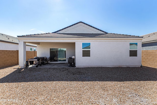 back of property featuring stucco siding, fence, and a patio