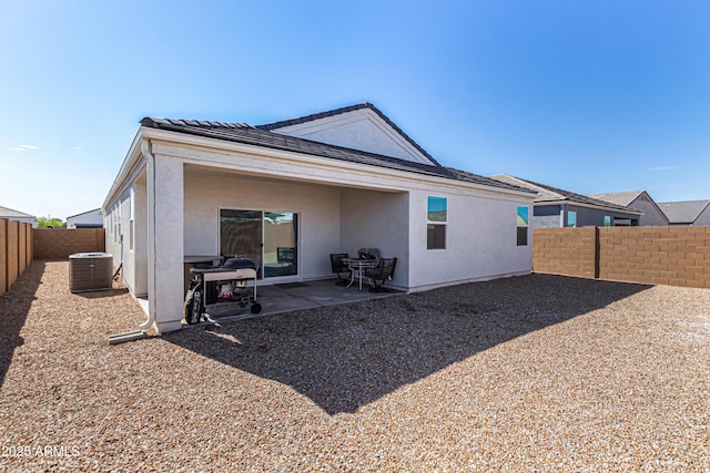 rear view of property with central air condition unit, a fenced backyard, a patio, and stucco siding