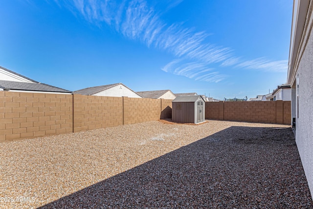 view of yard with a fenced backyard, an outdoor structure, and a shed