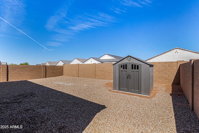 view of yard featuring a fenced backyard, an outdoor structure, and a storage unit