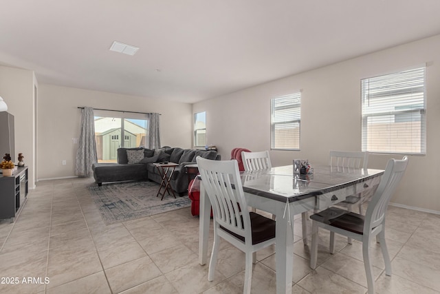 dining space with plenty of natural light, baseboards, and light tile patterned floors