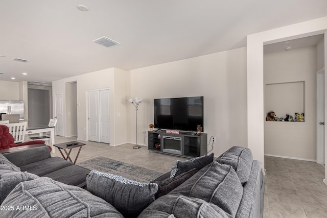 living area with baseboards and visible vents