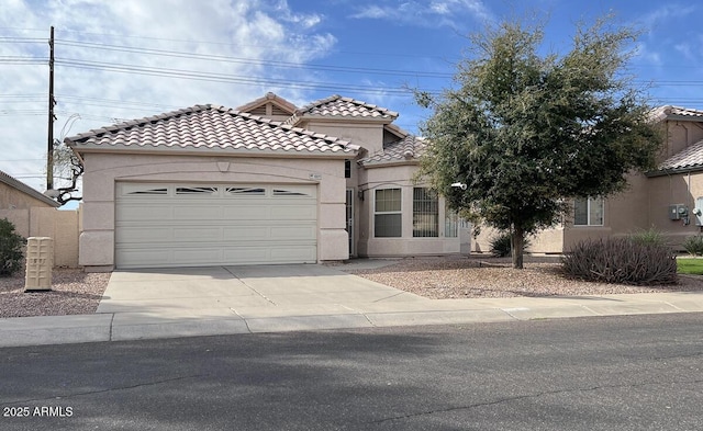 mediterranean / spanish home featuring a tiled roof, an attached garage, driveway, and stucco siding