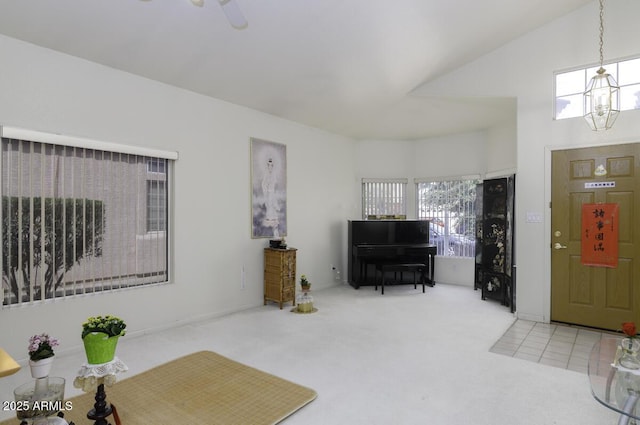 foyer entrance featuring ceiling fan with notable chandelier, tile patterned floors, and carpet