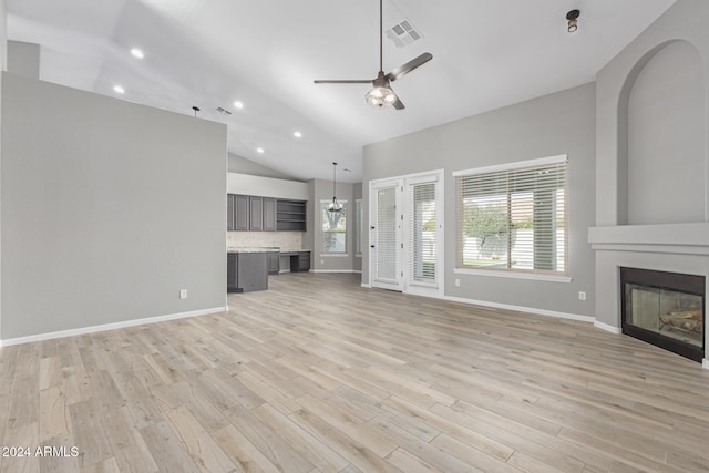 unfurnished living room with a fireplace, vaulted ceiling, light hardwood / wood-style flooring, and ceiling fan