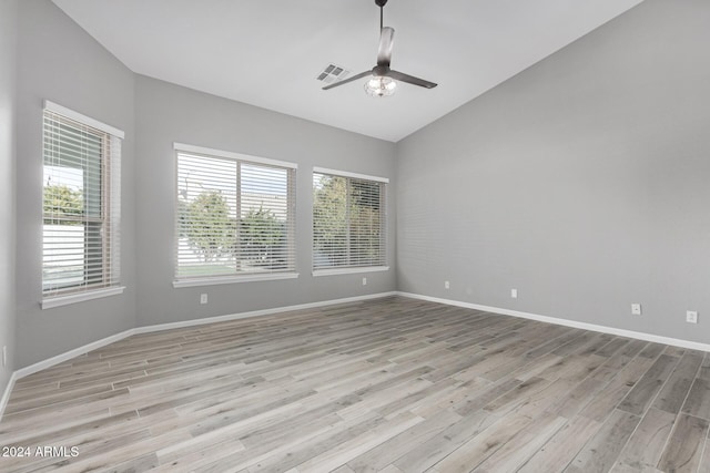 unfurnished room with ceiling fan, lofted ceiling, and light wood-type flooring