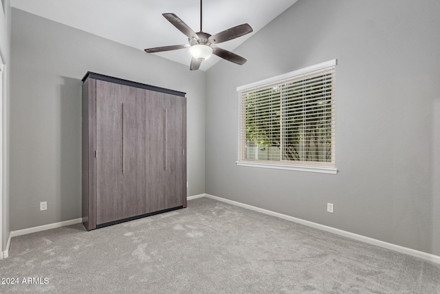 unfurnished bedroom featuring light carpet, ceiling fan, and lofted ceiling