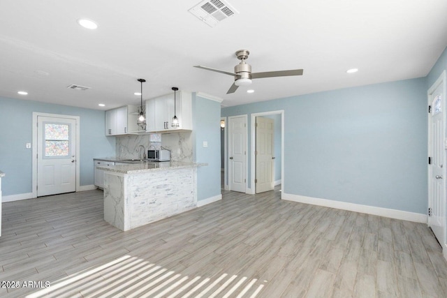 5011 S 20th Pl, Phoenix, AZ 85040 - kitchen featuring a sink, light wood finished floors, baseboards, white cabinetry, and recessed lighting