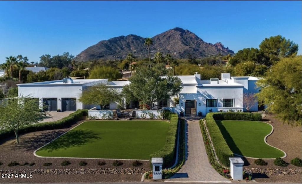 exterior space with a mountain view and a front lawn