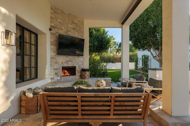 view of patio with an outdoor living space with a fireplace