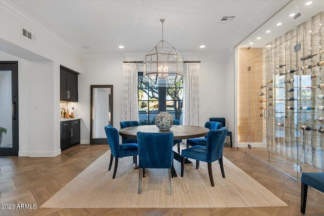 dining space featuring bar, light parquet flooring, a chandelier, and ornamental molding