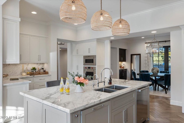 kitchen featuring dark parquet flooring, sink, stainless steel appliances, an island with sink, and white cabinets