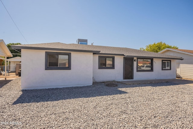 view of front of home featuring roof with shingles and stucco siding