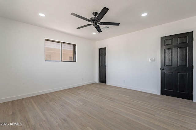 unfurnished room featuring light wood-type flooring, visible vents, and baseboards