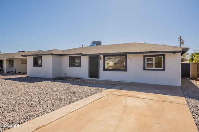 ranch-style house featuring a patio area, a shingled roof, fence, and stucco siding