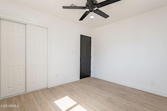 unfurnished bedroom featuring a closet, light wood-type flooring, visible vents, and baseboards