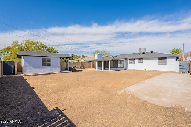 rear view of property featuring a patio area, a fenced backyard, and stucco siding