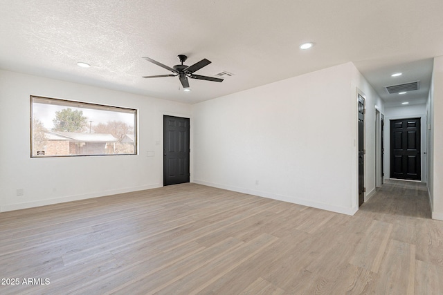 unfurnished room with light wood-type flooring, visible vents, and baseboards