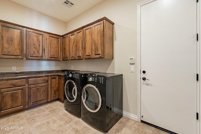 washroom featuring cabinet space, baseboards, visible vents, and separate washer and dryer