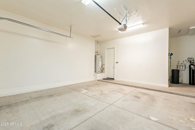 garage featuring a garage door opener, gas water heater, and baseboards