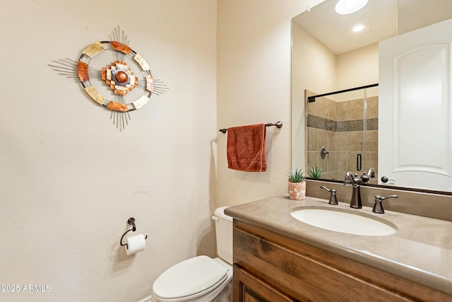 full bathroom featuring toilet, a shower stall, and vanity