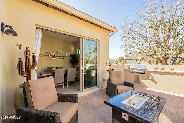 view of patio featuring an outdoor living space with a fire pit, area for grilling, and an outdoor kitchen