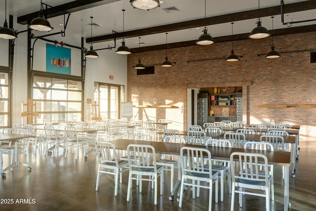 unfurnished dining area with beam ceiling, brick wall, visible vents, and a high ceiling