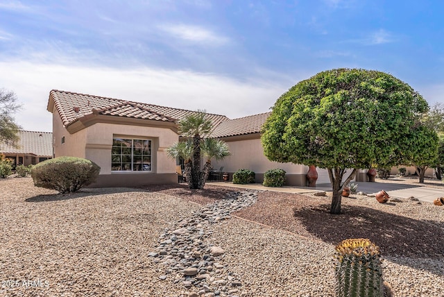 mediterranean / spanish house with a tiled roof, stucco siding, driveway, and an attached garage