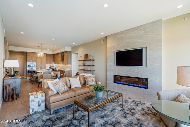 living room with wood-type flooring and a tile fireplace