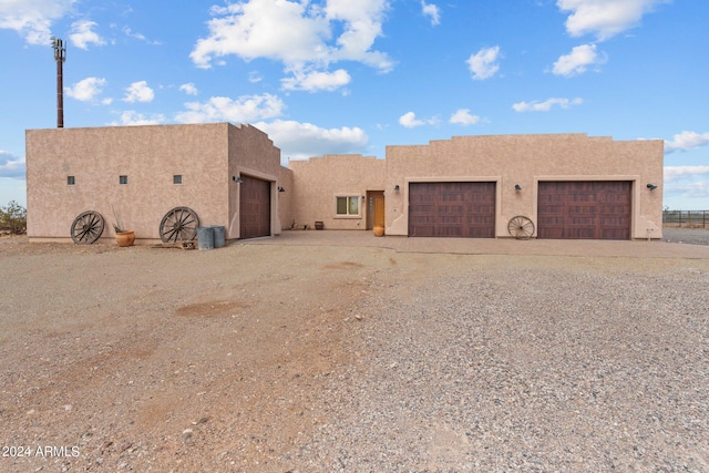 pueblo-style home featuring driveway and stucco siding