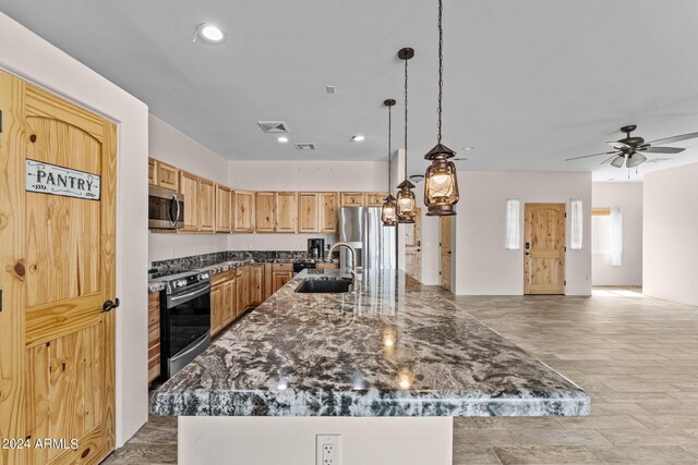 kitchen with appliances with stainless steel finishes, sink, decorative light fixtures, a kitchen island with sink, and ceiling fan