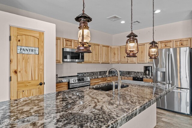 kitchen with light brown cabinets, stainless steel appliances, light hardwood / wood-style floors, decorative light fixtures, and sink