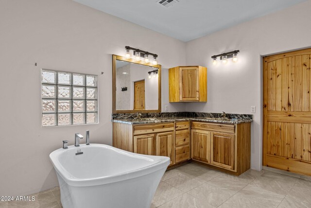 bathroom with a washtub, tile patterned floors, and double sink vanity