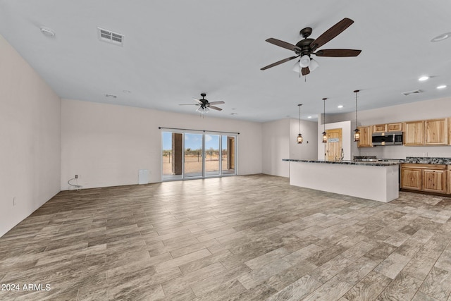 unfurnished living room with ceiling fan