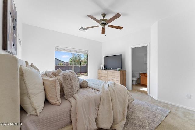 carpeted bedroom with ensuite bathroom and ceiling fan