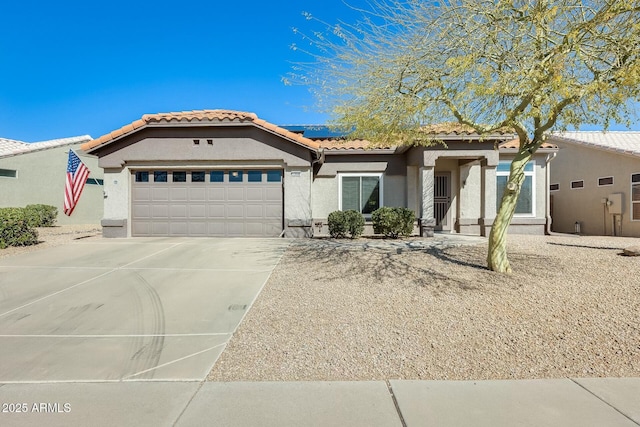 view of front of home featuring stucco siding, driveway, roof mounted solar panels, a garage, and a tiled roof