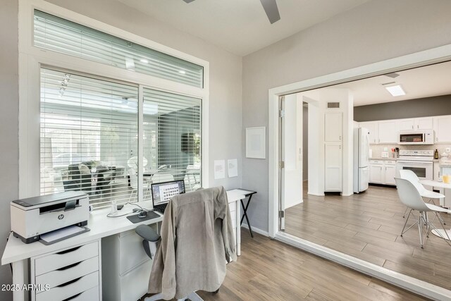 office space featuring light wood-type flooring, baseboards, visible vents, and ceiling fan