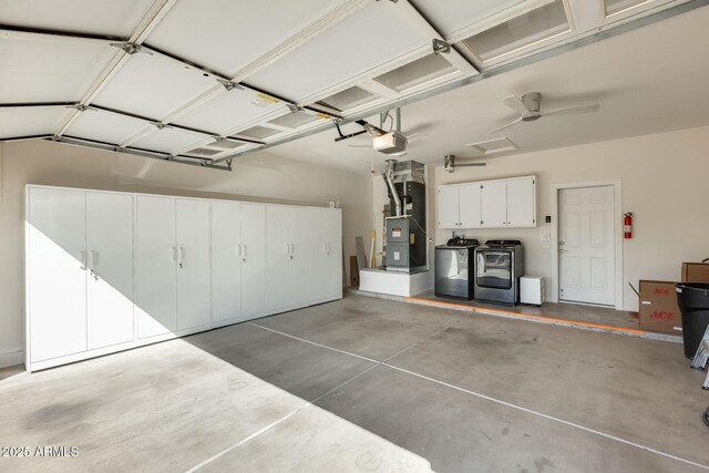 garage with heating unit, independent washer and dryer, and a garage door opener