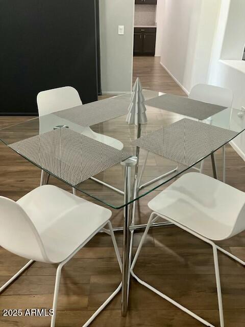 dining space featuring baseboards and wood finished floors