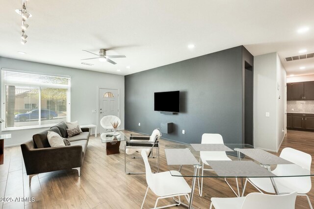 living room featuring visible vents, baseboards, ceiling fan, light wood-type flooring, and recessed lighting