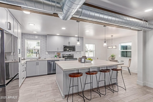 13012 N 36th Dr, Phoenix, AZ 85029 - kitchen with stainless steel appliances, backsplash, a kitchen bar, plenty of natural light, and recessed lighting