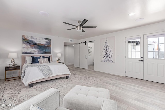 13012 N 36th Dr, Phoenix, AZ 85029 - bedroom with a barn door, light wood-style floors, and a ceiling fan