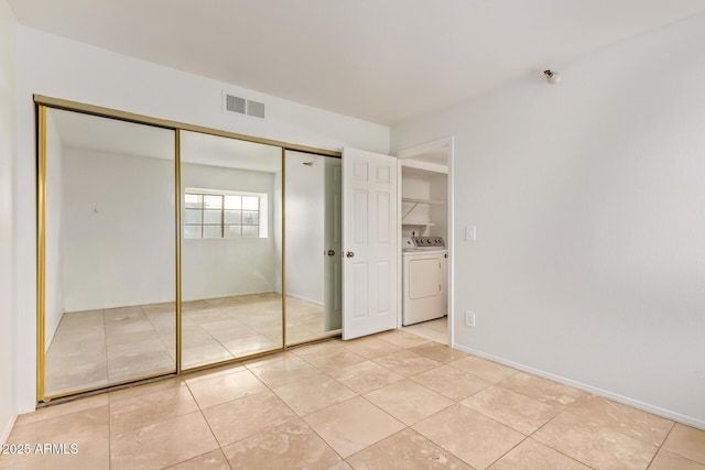 unfurnished bedroom with light tile patterned floors, visible vents, a closet, and washing machine and clothes dryer