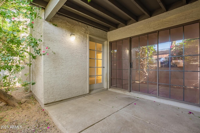 property entrance with a patio area and stucco siding