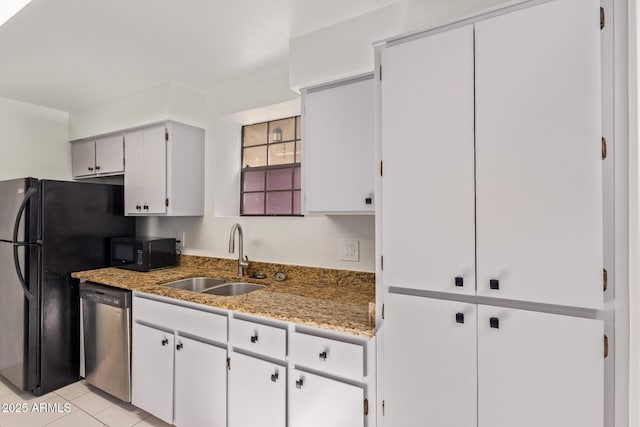 kitchen with light tile patterned floors, black appliances, a sink, and light stone countertops